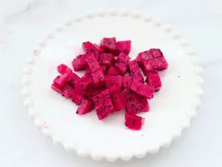 火龙果蔓越莓麦片酸奶昔,火龙果去皮后，用刀切成小丁。