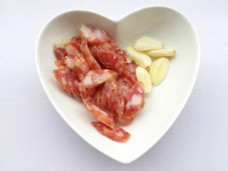 荷兰豆炒腊肠,腊肠切斜片，大蒜去皮拍扁。