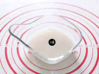 没有烤箱照样做出香浓芝士风味薄底披萨,首先将酵母、糖和适量温水(40~50ml左右)混合均匀,静置10分钟。当液体中陆续有泡泡冒出,酵母就被充分唤醒了。酵母很喜欢糖,在唤醒酵母的过程中,加入糖可以让酵母变得更为活跃,温水也是同样的道理。这里切勿使用开水,会将酵母烫死。