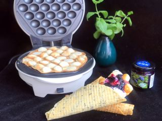 香港名小吃鸡蛋仔,用鸡蛋卷包住鸡蛋仔,淋上浓稠酸奶和蔓越莓果酱,蓝莓味的酸奶冰激淋鸡蛋仔就好了,鸡蛋仔热着吃松软香甜,凉了吃嘎嘣脆的!