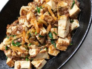 咸蛋豆腐(快手菜),最后出锅前放入葱花,盛出装盘,面上再放点榨菜装饰。