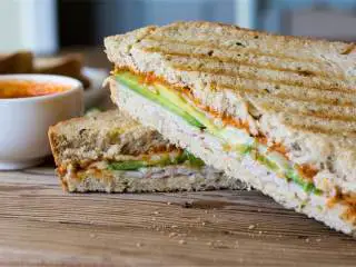 土耳其风味牛油果帕尼尼,把帕尼尼放进煎盘，煎至面包变脆，芝士融化。如用平底锅，中文煎制两面金黄即可。