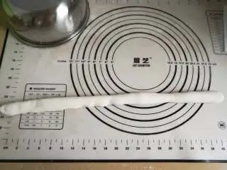 家乡小吃——小米,先取一块面团来回折叠,然后搓成细条状,以此判断水分是否合适,正常状态应该是可以扯断,但稍微费力;如果很容易断说明水少了,扯不断变得更细则说明水加多了