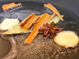 老上海风味的红烧肉,锅中热油,将香叶,桂皮,八角,姜片煎香