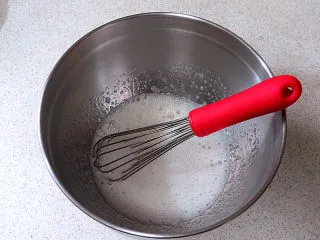 醇厚风味的咖啡百利甜费南雪,蛋白、糖、水饴一起放入盆内，用手抽混合稍微搅打，至糖融化，蛋白有细密的气泡即可，不需要过度打发