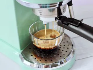 黄桃养乐多冰咖啡,把咖啡粉放入咖啡机开始萃取咖啡。