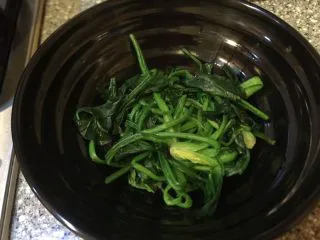 乡味~重庆小吃红油抄手,菠菜放入碗中。