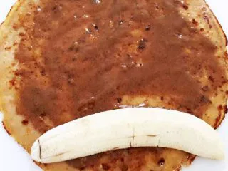 瑞典风味香蕉榛子酱薄饼-带着宝宝吃遍全球......,在每张薄饼上均匀抹上薄薄一层榛子酱，并且将半面香蕉在饼的一侧 ps:不习惯榛子酱味道的，可以改用芝麻酱等代替