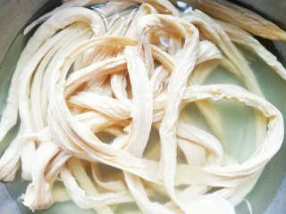 超级爽口的凉拌腐竹,准备材料：腐竹450g、胡萝卜半根、大蒜15颗、辣椒粉适量、香菜适量。取适量的腐竹放入盆中，倒入30-40度左右的温水没过腐竹，加入一勺食盐浸泡20分钟。 