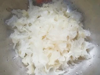 百变水果 苹果香橙银耳羹,泡发的银耳撕成碎片洗干净。