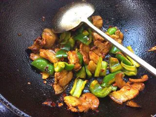 辣子蒜苗回锅肉,放入辣子翻炒，放少许生抽，料酒