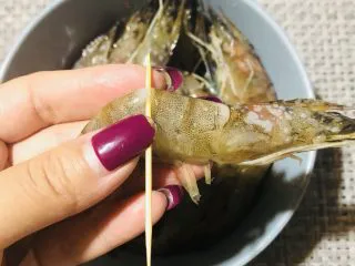 普罗旺斯风情烤虾,用牙签插入虾背部第三个关节内，挑出虾线。