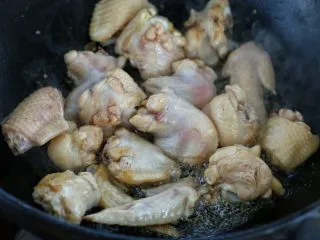 鸡翅腐竹烧土豆,锅中倒适量食用油烧热,放入鸡翅翻炒至发白变色