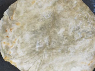 街头手抓饼的吃法----懒人必备早餐,放入手抓饼生胚,煎至一面定型后翻个面在煎至另一面,直到煎至两面稍微油金黄色