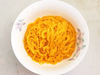 风味炒面 芽菜肉末炒玉米面,把煮好的玉米面条捞到一个大碗里