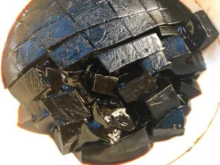 黑凉粉水果捞,冷藏好以后,把黑凉粉取出,用刀切成小块待用。
