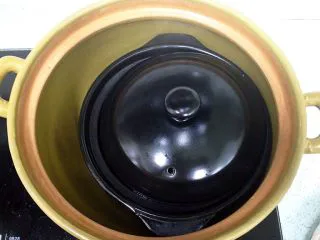 新奥尔良风味砂锅翅,取一个大砂锅，坐火加热，再把小砂锅整个放入大砂锅，盖好盖子，关火，焖10分钟。