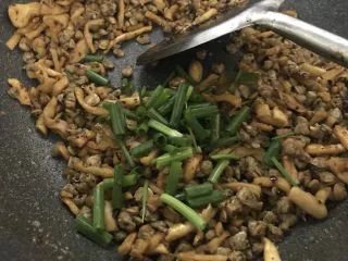 萝卜干炒蚬肉（麻辣风味）,炒香后放入葱花，翻炒几下就可以装碟了。