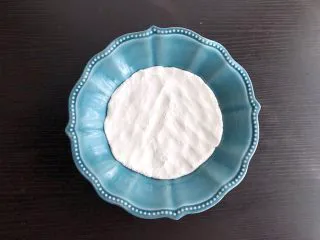 老北京驴打滚,盘子中刷油,将面团平铺在盘中