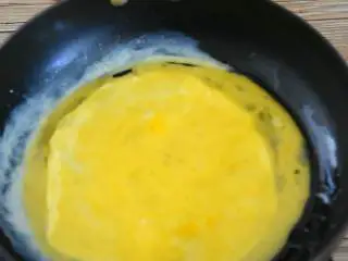 抱蛋千张卷—看世界杯没有宵夜怎么行,热锅刷少许油,小火倒入一半蛋液,轻轻推开。