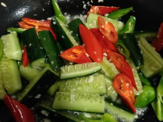 美味宵夜小龙虾,十几秒后，待蒜蓉散发出香味，放入黄瓜、青椒、红椒爆炒