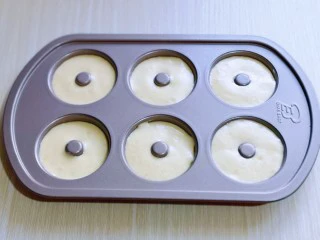 烘焙小白必做～萌狗甜甜圈,再将原味的蛋糕糊倒入新的裱花袋中，挤入甜甜圈模具中，8分满即可。