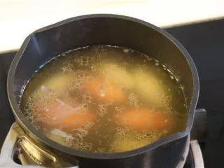 法式牛肉暖锅,一部分汤将配菜煮熟。剩下汤汁撇去油脂。