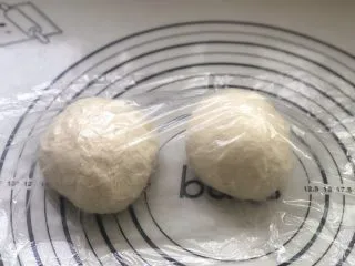 意式烤肠披萨,面团发酵好后，分成2份，滚圆松弛15分钟。