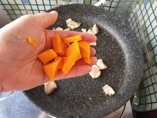 奶香南瓜鸡肉焗饭,放入南瓜丁，炒制。