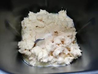 燕麦全麦羊角包,面包机桶内依次加入泡好的牛奶麦片、水、玉米油,糖和盐对角放,加入高筋面粉和全麦粉,将中种面团撕碎放入面包机桶内,最后加入干酵母。