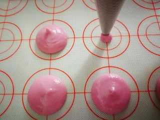 马卡龙~卡仕达酱内陷,铺上马卡龙硅胶垫垂直开始挤,要用力均匀,大小一致