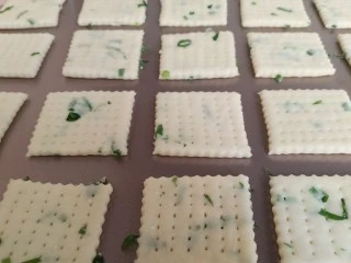 香葱苏打饼干,把饼干移到不沾烤盘上，每个之间都留点距离摆开