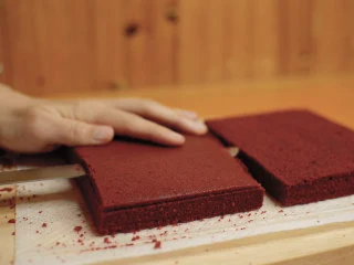 红丝绒蛋糕 无需酪乳 奶酪霜抹面,蛋糕彻底冷却后对半切开。 切掉不平整的部位，边角料先留着。 把两片蛋糕切成一毛一样。