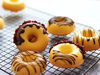 橙味甜甜圈蛋糕，在家就可复刻的经典美味,用裱花带剪个小口，放入巧克力，基础线条型，或者直接淋上巧克力粘上蔓越莓干。再撒一层椰蓉，就完成了。