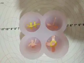 脆皮冰淇淋蛋糕,二， 巧克力脆皮 先将白巧克力隔水融化，分成两份，一份加粉色素，一份加黄色素，调匀！将两份色素装入裱花袋中，在模具内挤出衣服扣子和装饰 