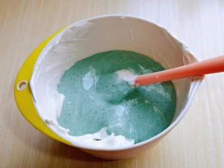 6寸蝶豆花戚风蛋糕,最后将蛋黄糊倒入蛋白霜的容器中,继续翻拌手法,直至看不到蛋白霜即可。