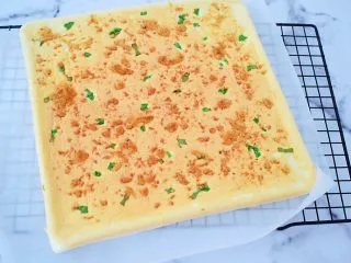 香葱肉松蛋糕卷,烤好马上取出震两下，把里面的热气震出来，再把蛋糕片倒扣在烤网上，拿掉烤盘，慢慢撕开油布，再翻正面过来晾至手温