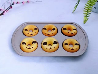 烘焙小白必做～萌狗甜甜圈,巧克力隔水融化，装入裱花袋，记得剪个很小很小的小口，手绘上眼睛与鼻子，嘴巴。