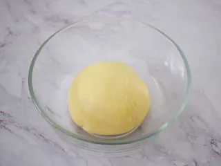日式炼乳手撕面包,取出揉圆放入容器中,放在温暖处发酵至两倍大左右