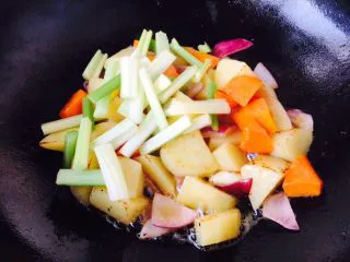 #食二星座# 罐焖牛肉(34图详细步骤),当土豆煎至表面有微微的金黄色时放入芹菜段,翻炒均匀。