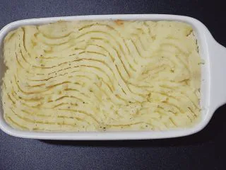 牧羊人派(Shepherd’s pie),铺上土豆泥,用叉子画出纹路。
