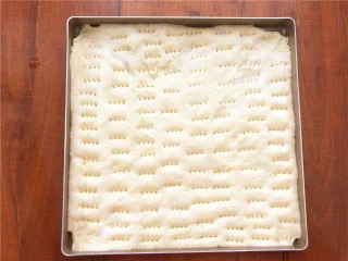 香葱肉松面包卷,预热烤箱的同时，用叉子在二发好的面包胚上扎满小孔，这样烤的时候不至于会中间变得鼓鼓囊囊。 