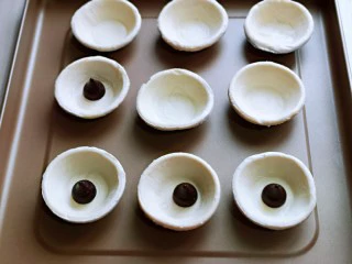 会爆浆的脏脏蛋挞～咬一口细滑醇香,把蛋挞皮放入烤盘中，放上巧克力。(巧克力可以任意选)