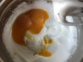 韩国草莓蛋糕,加入蛋黄,低速搅拌均匀。