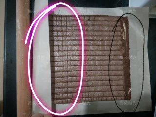 可可旋风蛋糕卷,晾网会在蛋糕表面留下一些痕迹,没关系。这个痕迹反而可以帮助更好的卷起来。蛋糕放在新的一张油纸或者油布上。切掉蛋糕的四边,然后在要卷的两端都斜着切掉一点边。黑色画线区域。在白色画线区域,切几道痕迹,但是不要切断。然后借助一根擀面杖卷起来。也可以抹上奶油或者果酱。我为了花纹好看什么也没有抹。