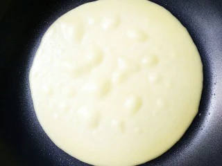 榴芒千层蛋糕,看到面糊变干起大泡了就可以用硅胶铲将其铲出来晾凉可,这个只要煎一面就可以了,因为皮很薄,煎一面就熟了!