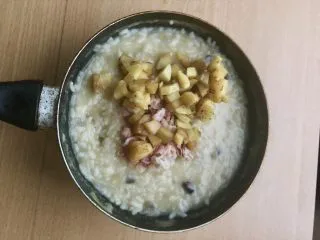 土豆苹果炖饭,叮好熟了的土豆好切好的培根放入炖饭中。转小火混合均匀。