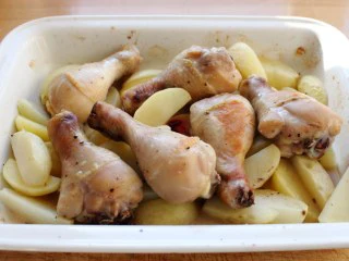 苹果柠香烤鸡腿,将已经烤了25分钟鸡腿带着烤盘取出。瞧到了吗？鸡的血污渗出来了，将盘子搞脏了。 