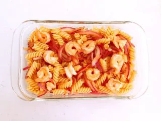 什锦虾仁焗意面,把炒好的虾仁螺丝面盛入耐高温的玻璃盘中