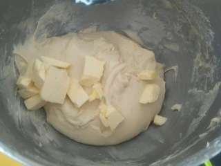 超软拉丝北海道土司(2个),等把面团都混合在一起形成可以拉出模 粗膜的面团后就加入50克软化黄油,继续盘它